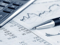 Image of calculator, pen, charts and documents.
