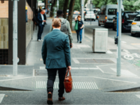 A businessman crosses the road in an Australian CBD