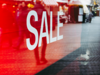 Closeup of a red sale sign inside a shop window., business valuation