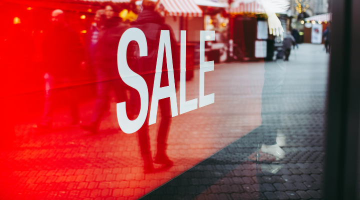 Closeup of a red sale sign inside a shop window., business valuation