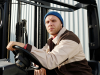 Man driving a truck in a beanie and jacket
