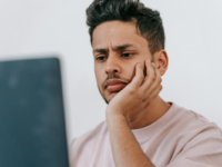 Man frowning down at his laptop