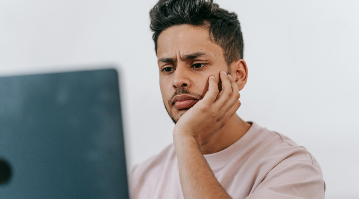 Man frowning down at his laptop