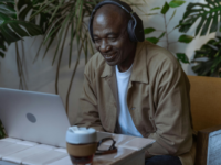 A man grinning down at a computer