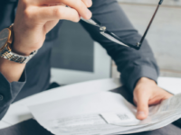 Man holding paper and glasses