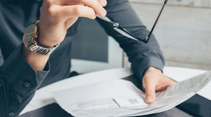 Man holding paper and glasses
