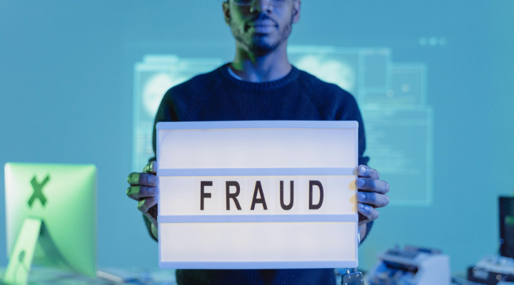 Man holding up fraud sign