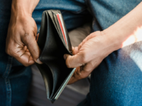 Man looking at empty wallet