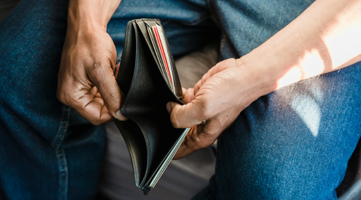 Man looking at empty wallet