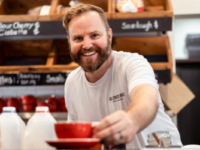 MAn serving coffee at cafe counter
