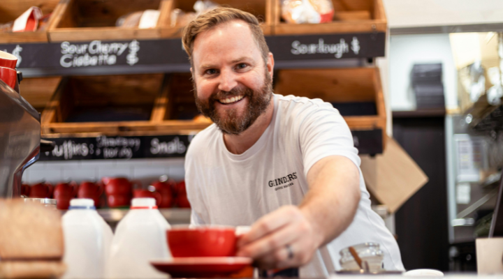 MAn serving coffee at cafe counter