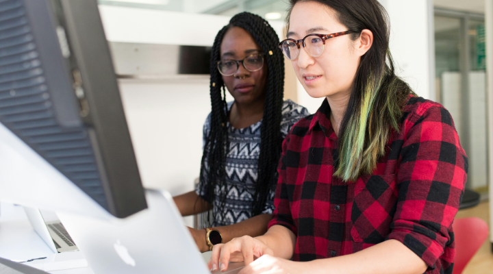 woman-with-red-black-checkered-shirt-typing-into-computer