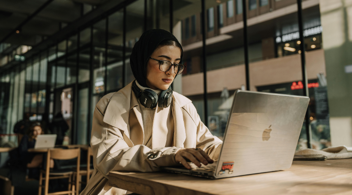 Woman working on laptop in coworking space.