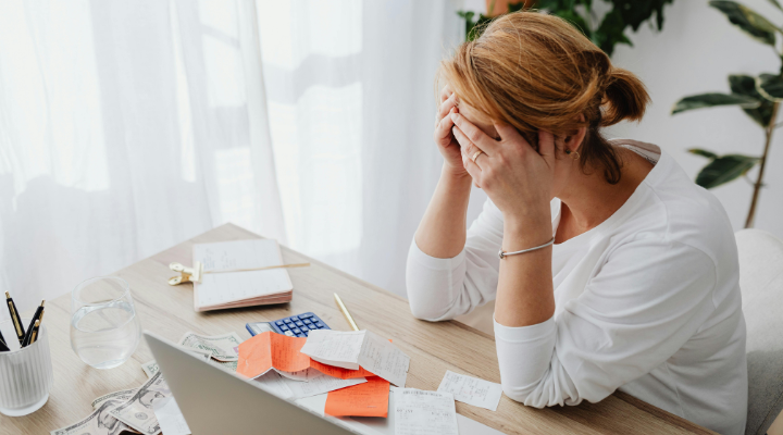 woman-sitting-messy-desk-face-in-hands