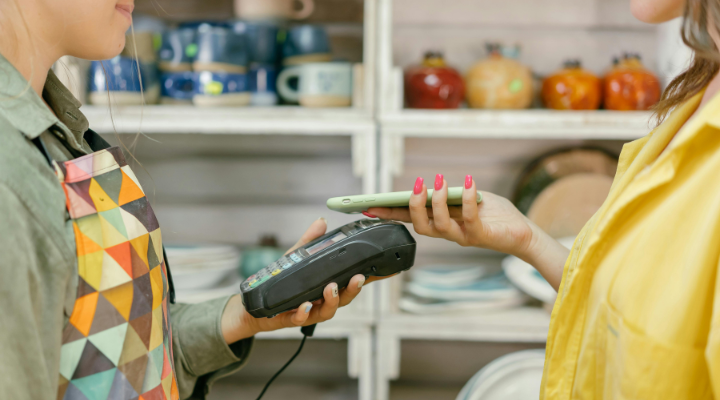 Side view of woman tapping eftpos reader with phone.