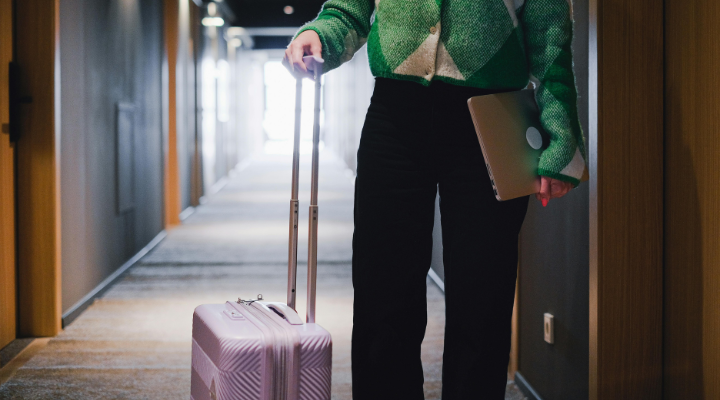 Woman with suitcase and laptop.